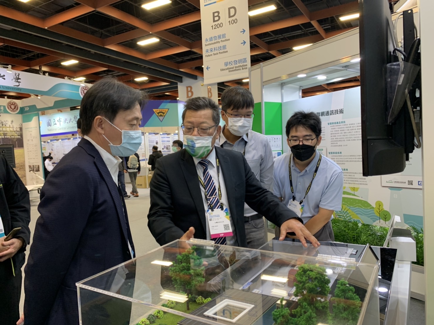 總經理(左2)與韋峰能源李董事長(左1)於「利嘉淨水場及南化淨水場小水力發電」展攤討論展示技術內容